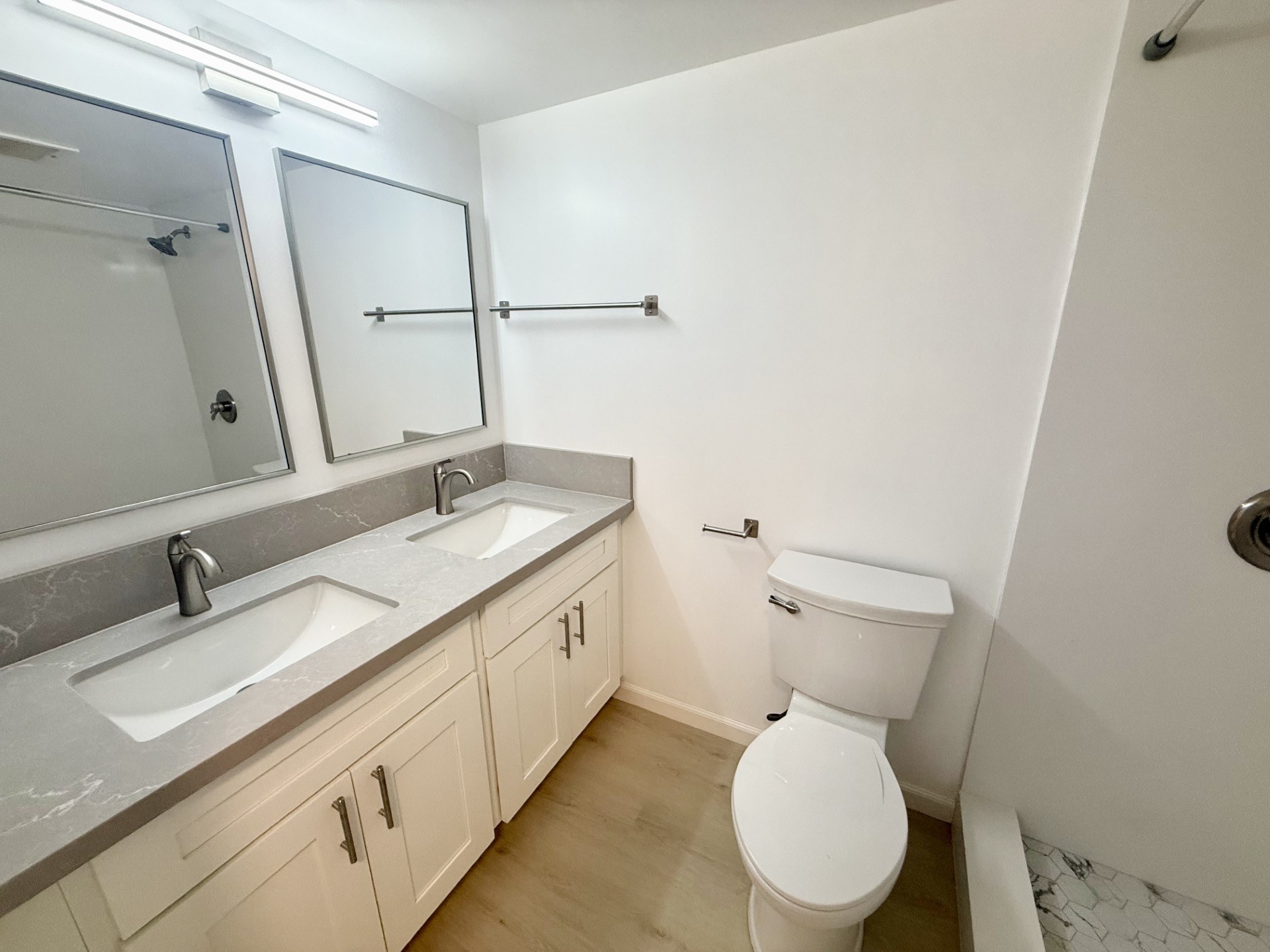 A white toilet sits next to a sink in a bathroom.